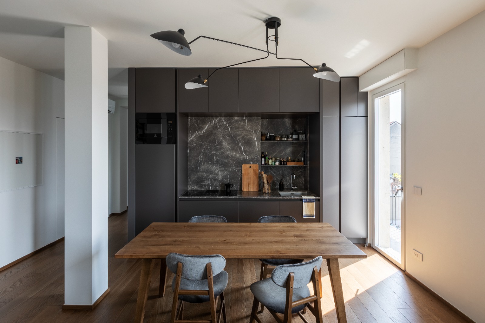 APT Milano - Cucina antracite con tavolo legno e lampada Serge Mouille